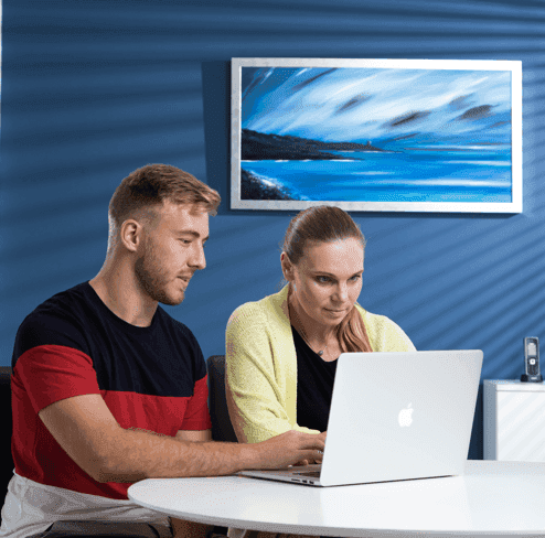 Two people working on a laptop