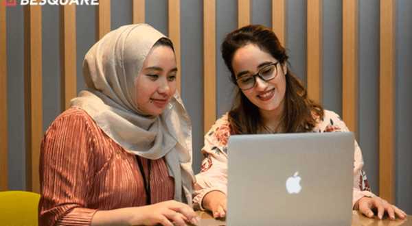 Two women looking at a laptop researching graduate programmes in Malaysia and BeSquare